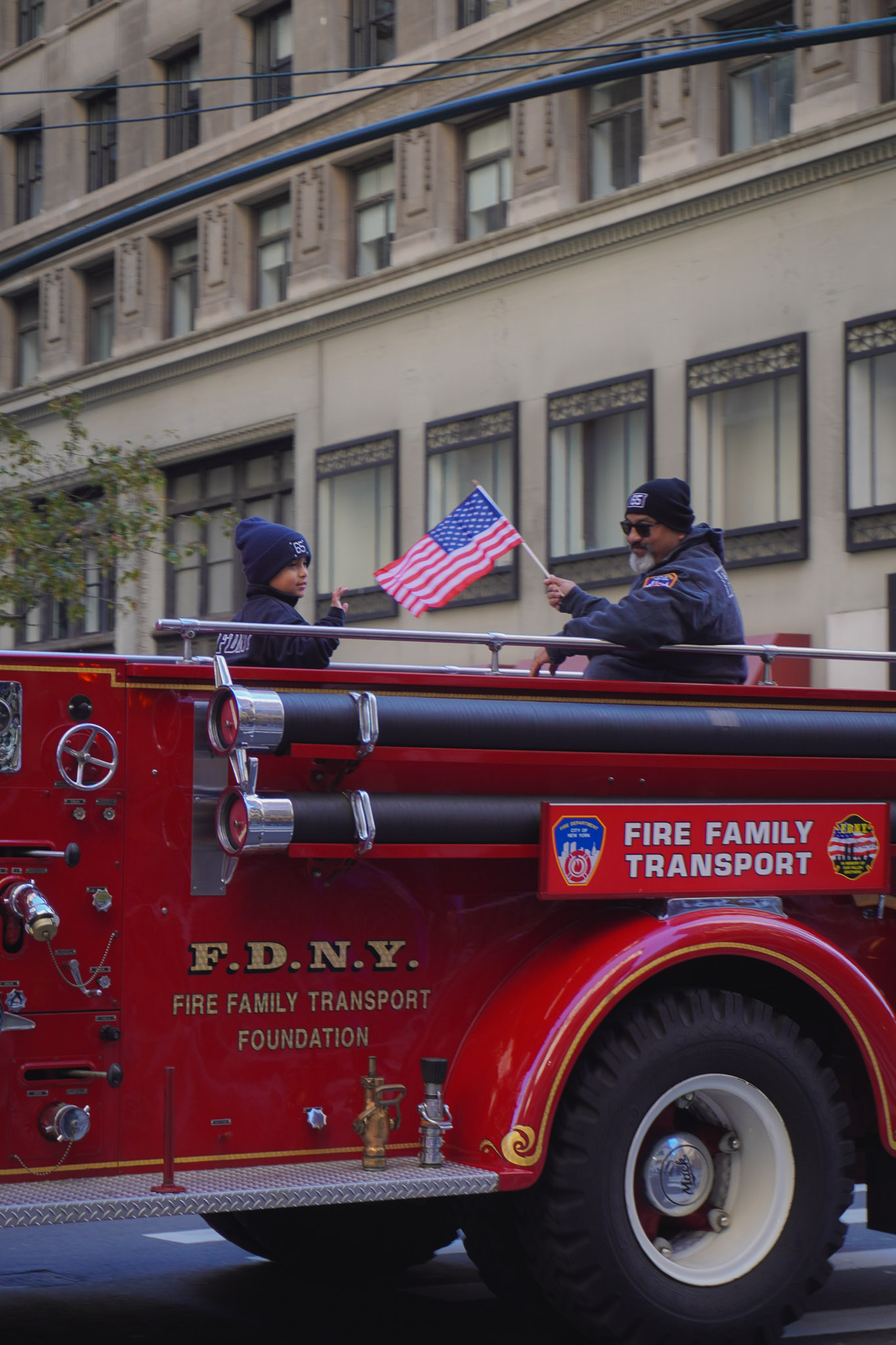 défilé des vétérans novembre 2023 à New York : un homme et un enfant défile dans un camion pompier