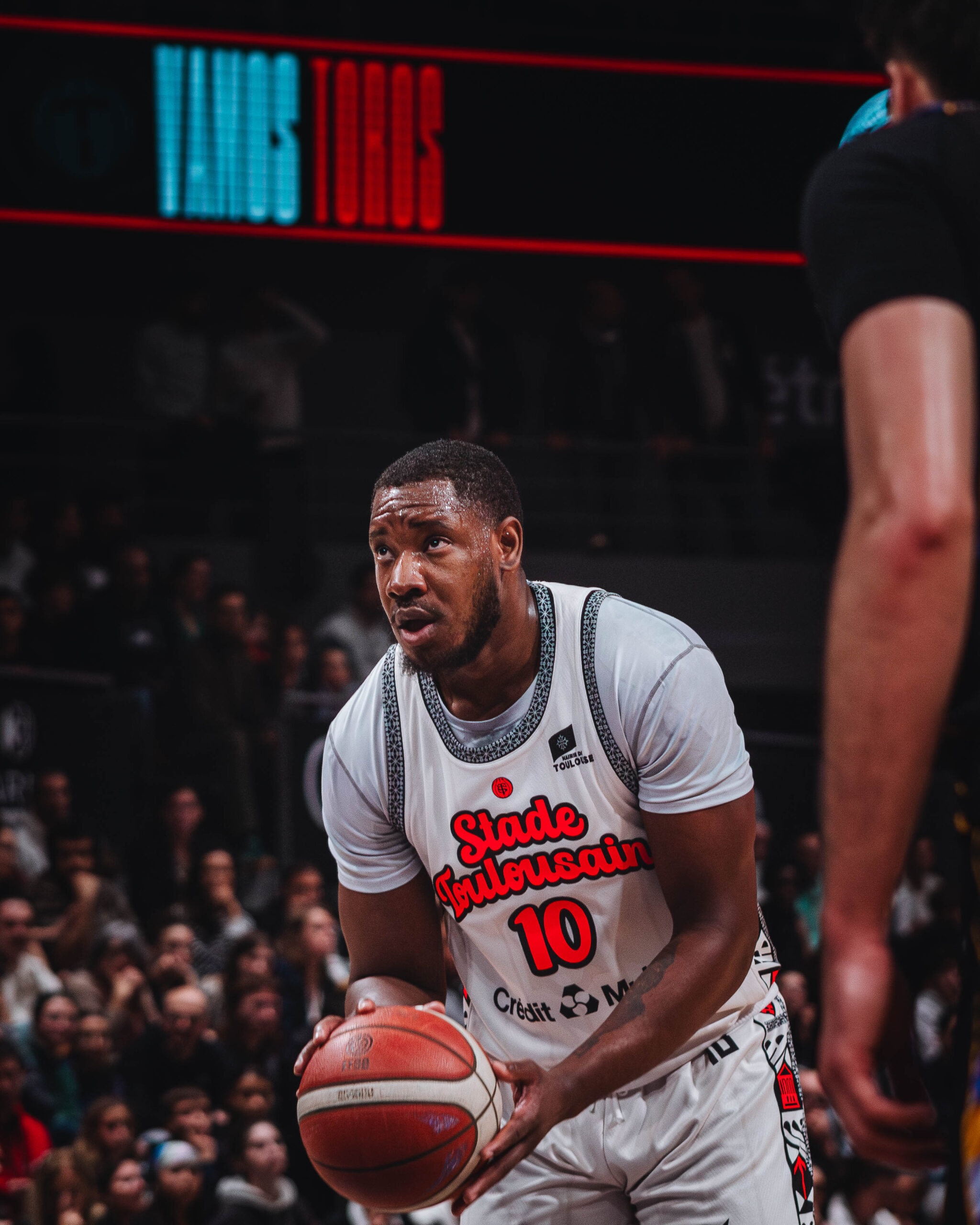 a man in a white jersey holding a basketball