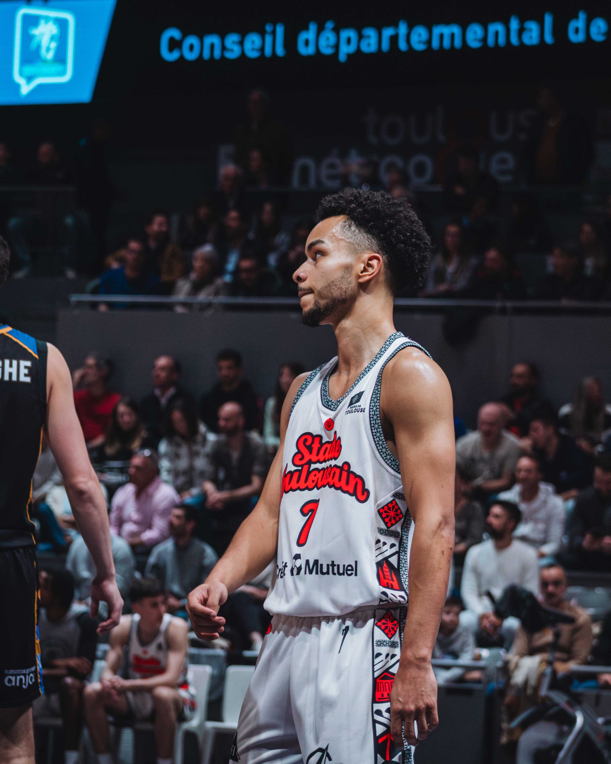 a basketball player in a white jersey with a red and black design on the back