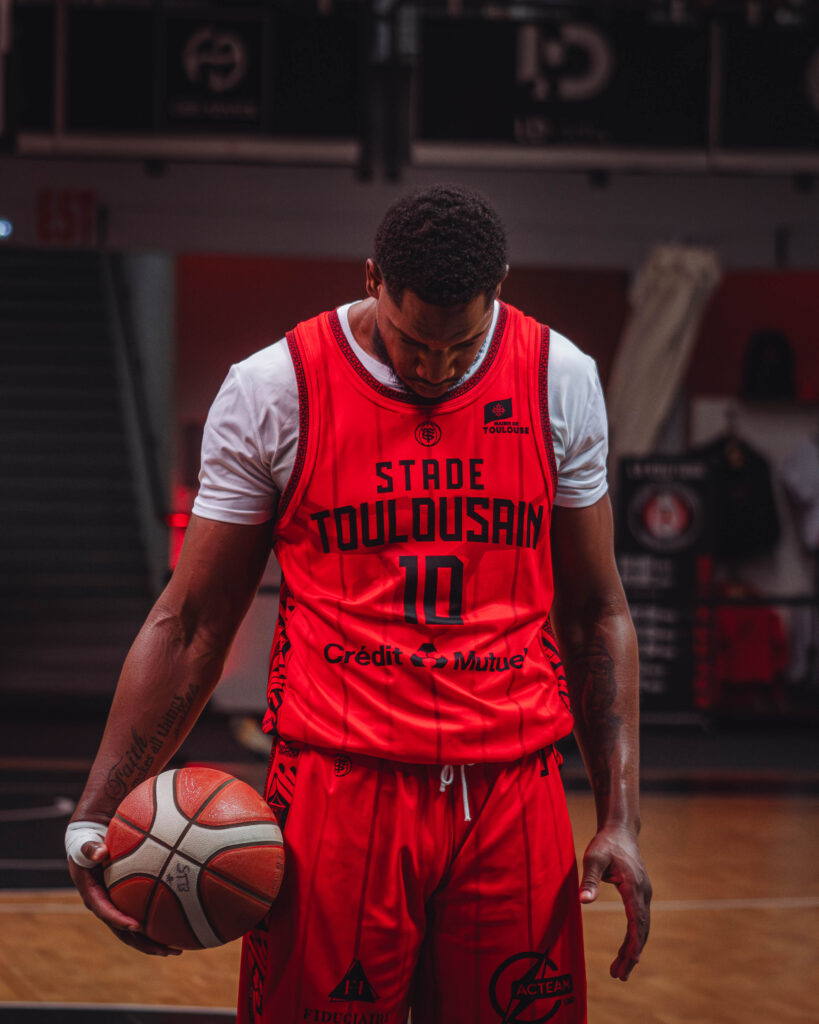 a man in a basketball uniform holding a ball