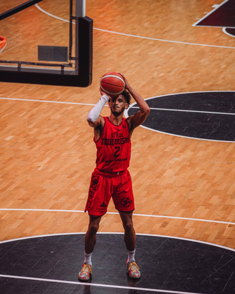 a man in red uniform holding a basketball